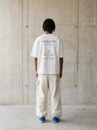 Tshirt by Wolvyn Apparel; white oversized boxy tee with black Foundations print on back