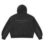 Hoodie back view in black fleece with FOUNDATIONS LAYER 02 text, Wolvyn Apparel Foundations collection.