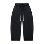 Unisex mineral-wash barrel-leg pants in black with white drawstrings and red V logo