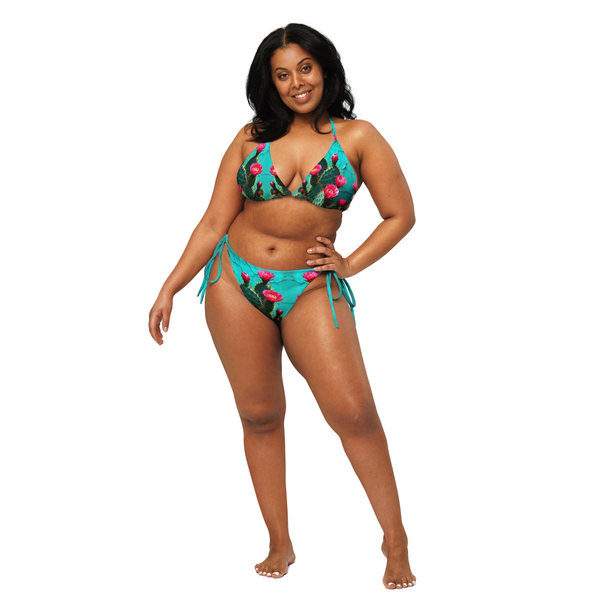 Woman wearing a turquoise cactus print string bikini, front view on white background