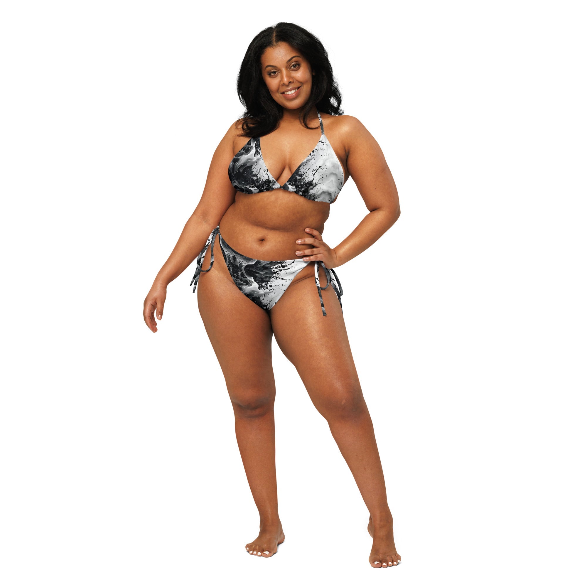 Woman modeling black and white marble print string bikini with side ties on white background