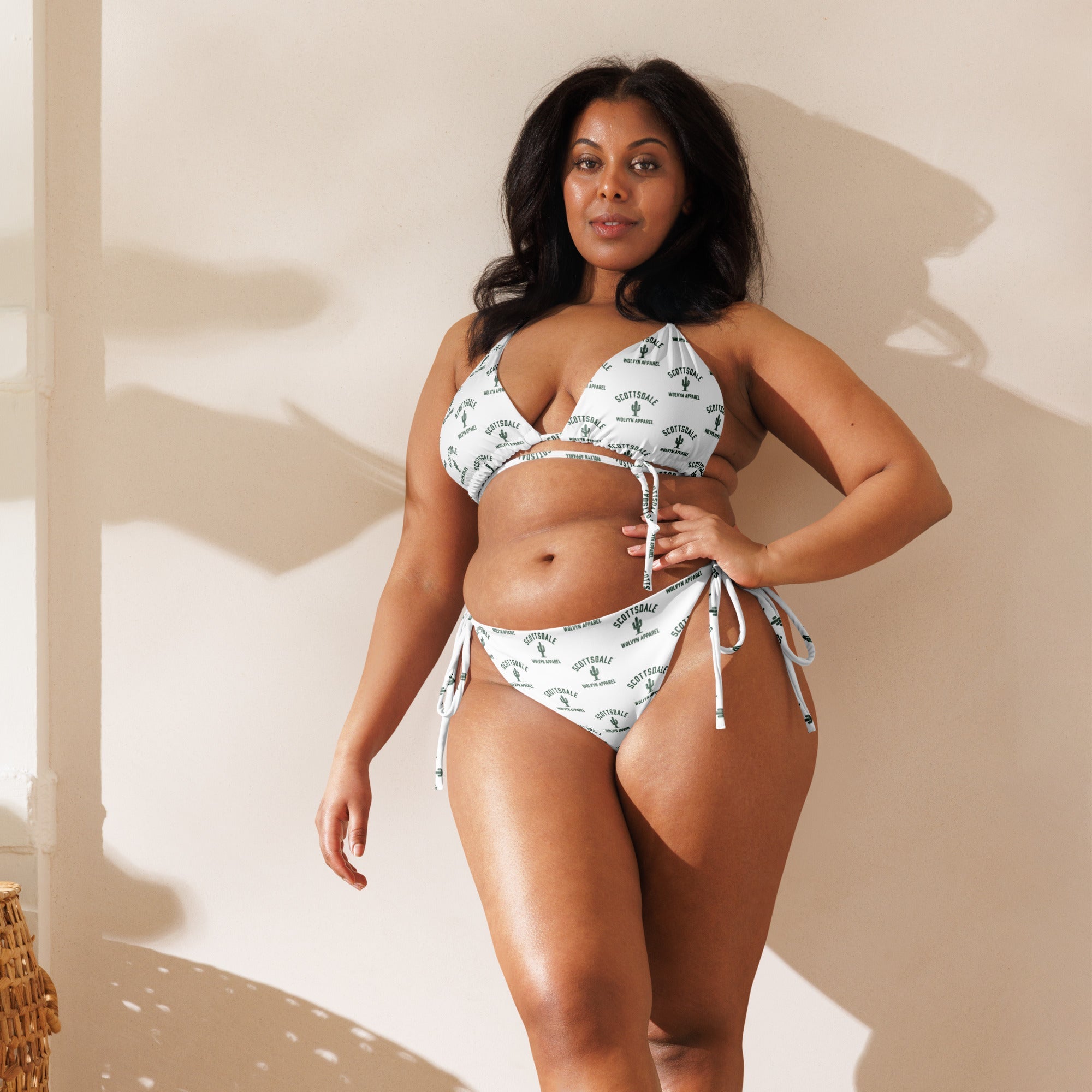Plus size model in white all-over print string bikini with tie sides, natural light setting