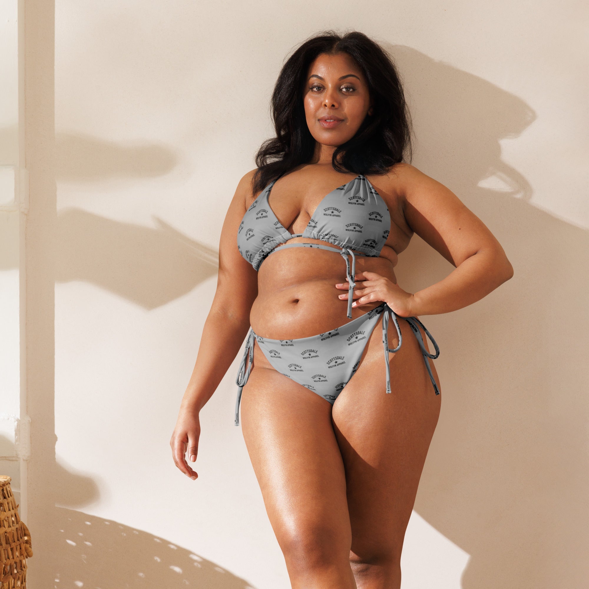 Woman modeling all-over print recycled string bikini with tie sides in natural light