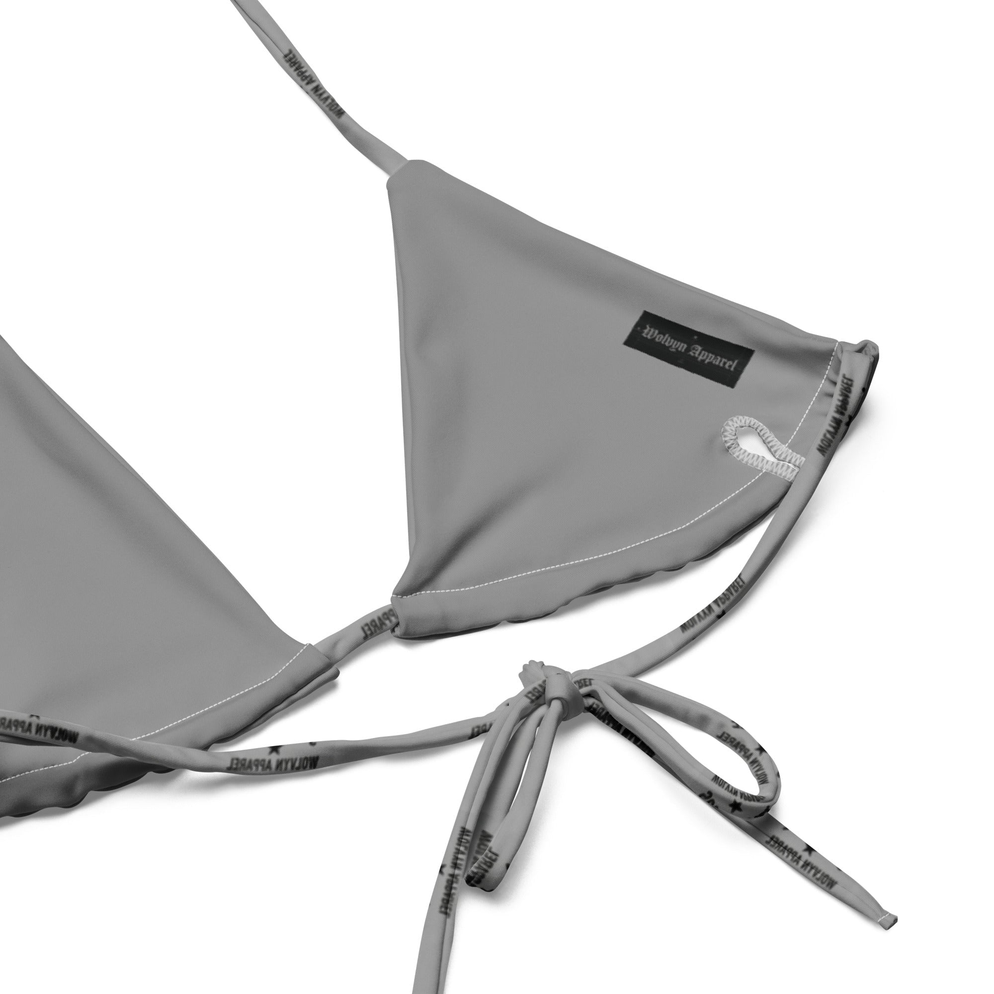Close-up of recycled string bikini top with adjustable straps and subtle text print