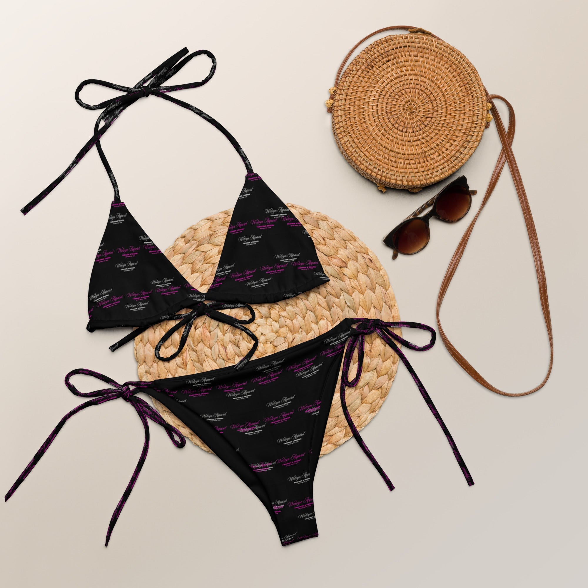 Black all-over print string bikini set with adjustable ties, styled with sunglasses and a woven round bag on a neutral background.