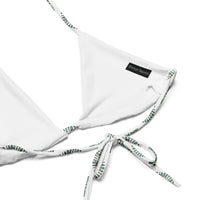 White recycled string bikini top with printed ties and small black logo tag on white background