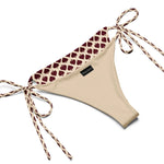 Beige string bikini bottom with maroon heart pattern and adjustable side ties