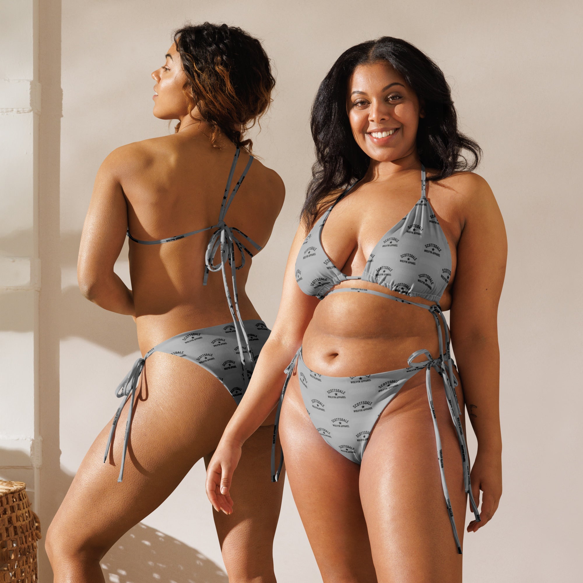 Two women modeling recycled string bikinis with all-over print in natural light