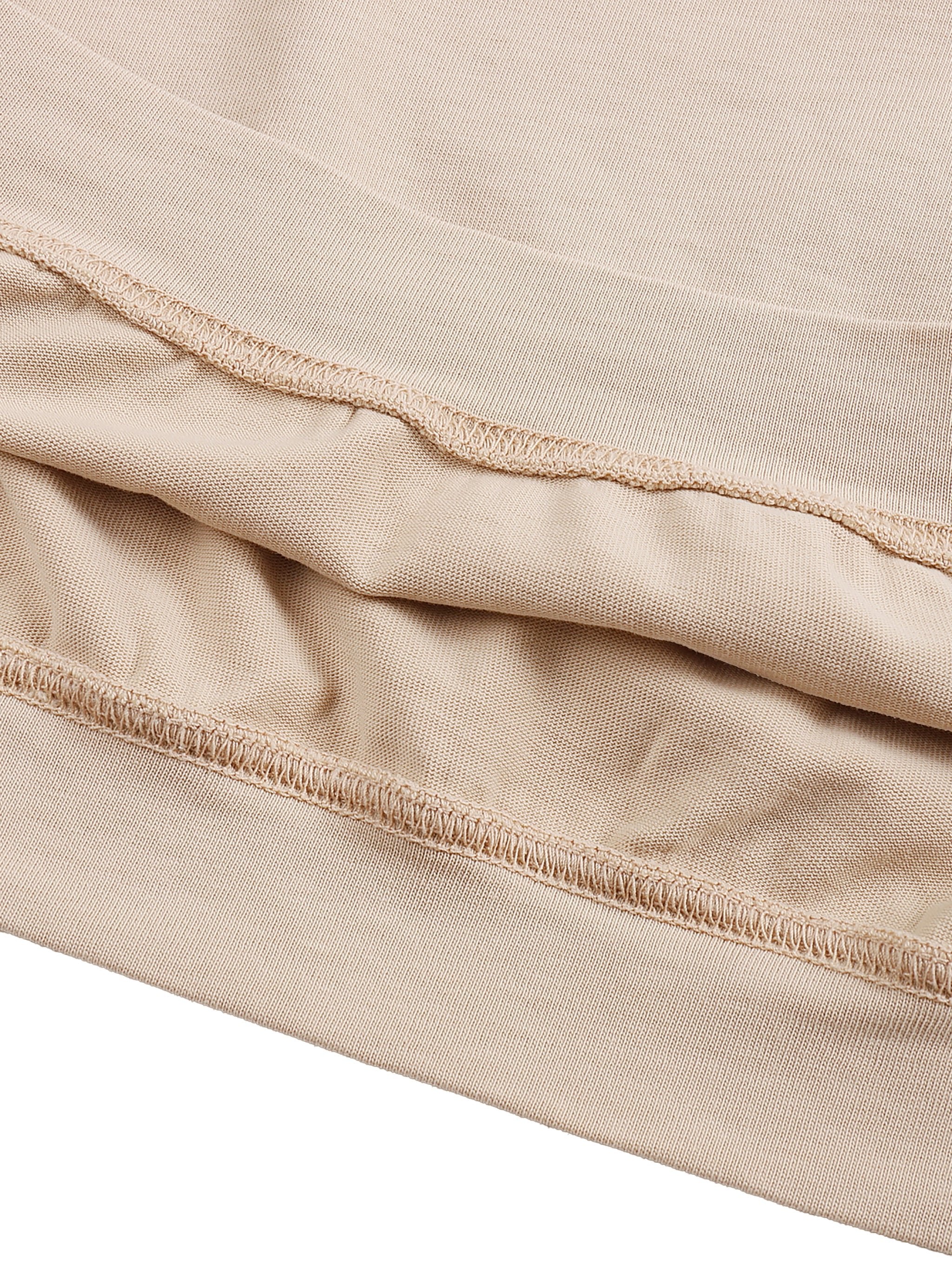 Close-up of beige oversized cotton T-shirt hem with visible stitching detail