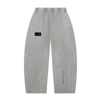 Villain pants, unisex gray mineral-wash barrel-leg with elastic waist; black patch on thigh and red vertical branding.