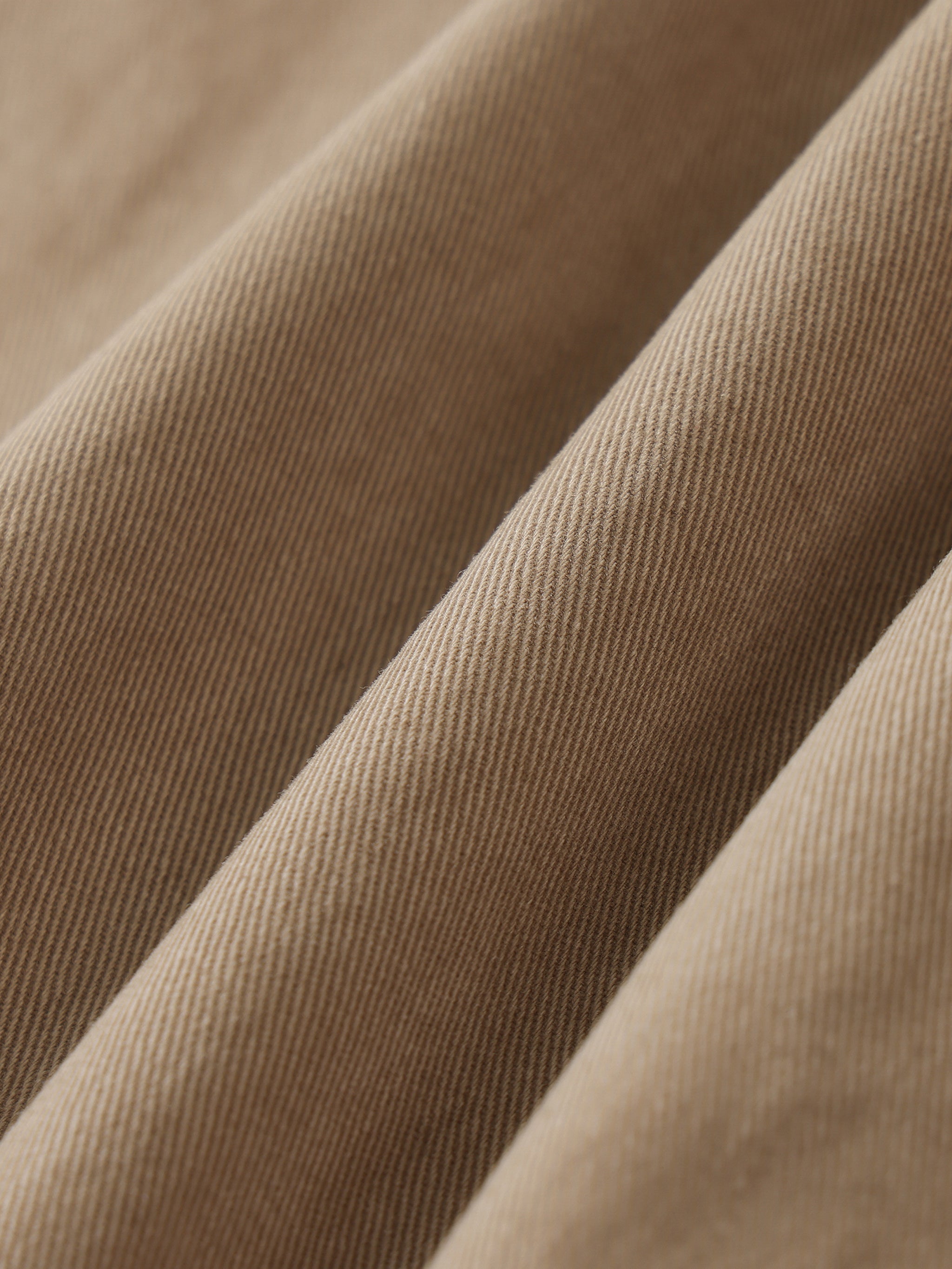Close-up of khaki cotton twill fabric, showing durable, elastic texture for cargo pants
