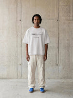 Tshirt: Foundations Stone oversized boxy tee in stone gray with black text, Wolvyn Apparel.