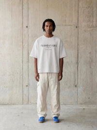 Tshirt: Foundations Stone oversized boxy tee in stone gray with black text, Wolvyn Apparel.