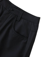 Close-up of black barrel dress pants with button waist, front pocket, and belt loop details