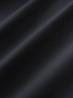 Close-up of smooth black dress pants fabric with soft diagonal folds