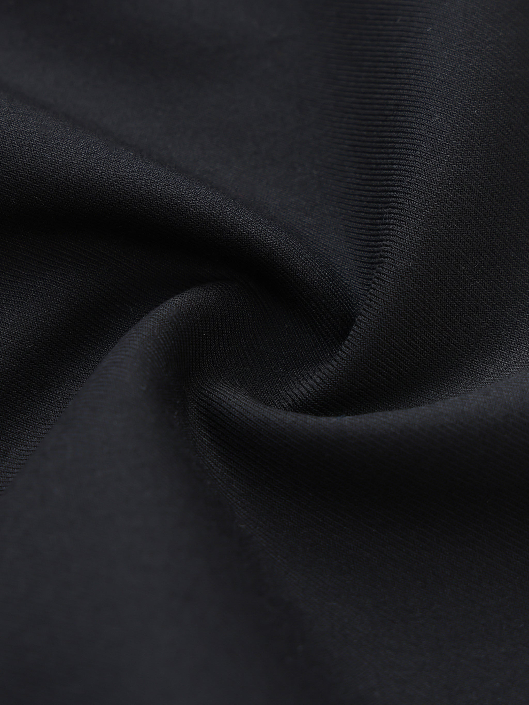 Close-up of black dress pants fabric with soft texture and elegant drape