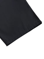Close-up of black barrel dress pants hem on white background