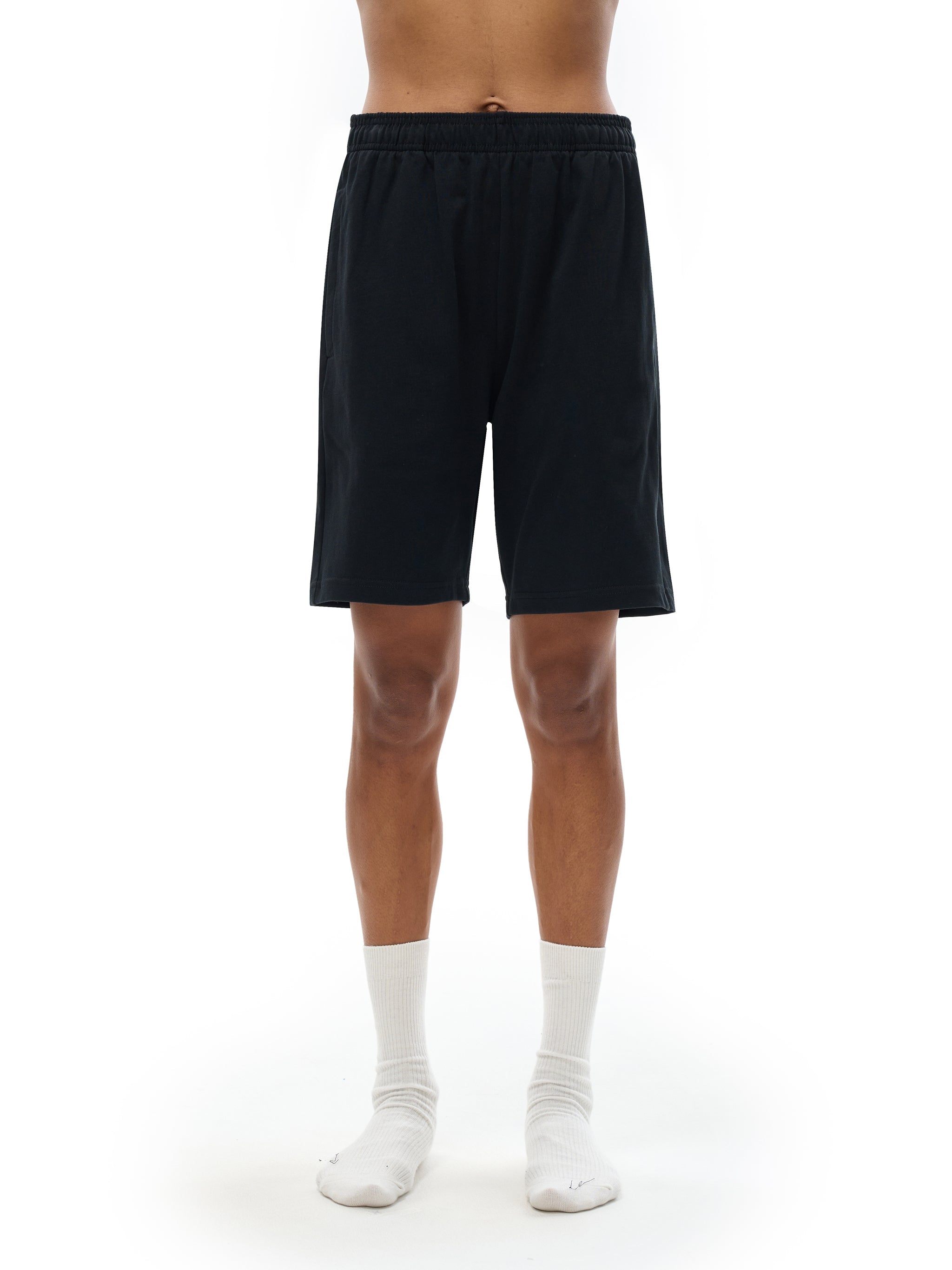 Black heavyweight cotton shorts with elastic waistband on model, minimalist streetwear