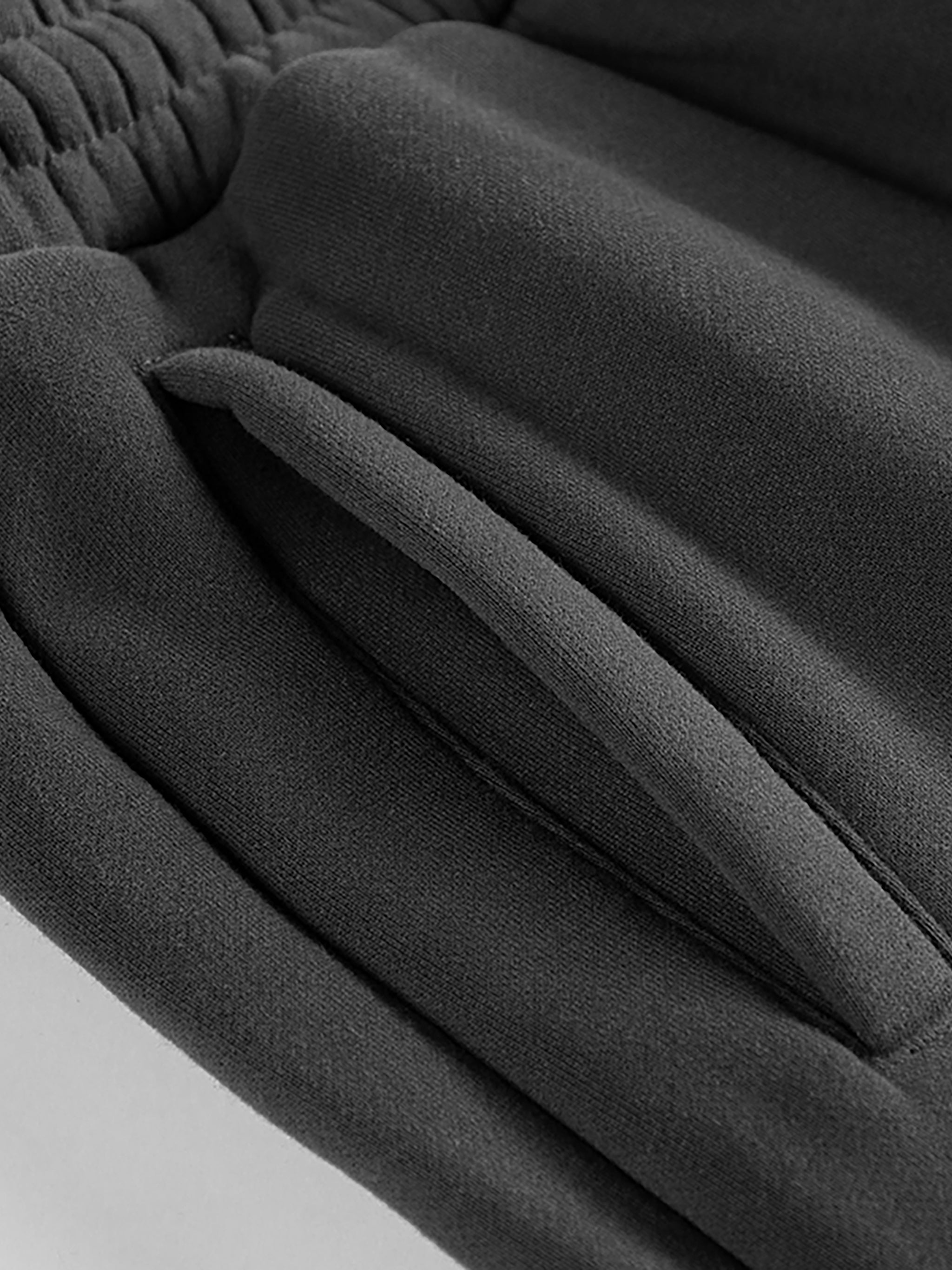 Close-up of black heavyweight streetwear sweatpants pocket with elastic waistband