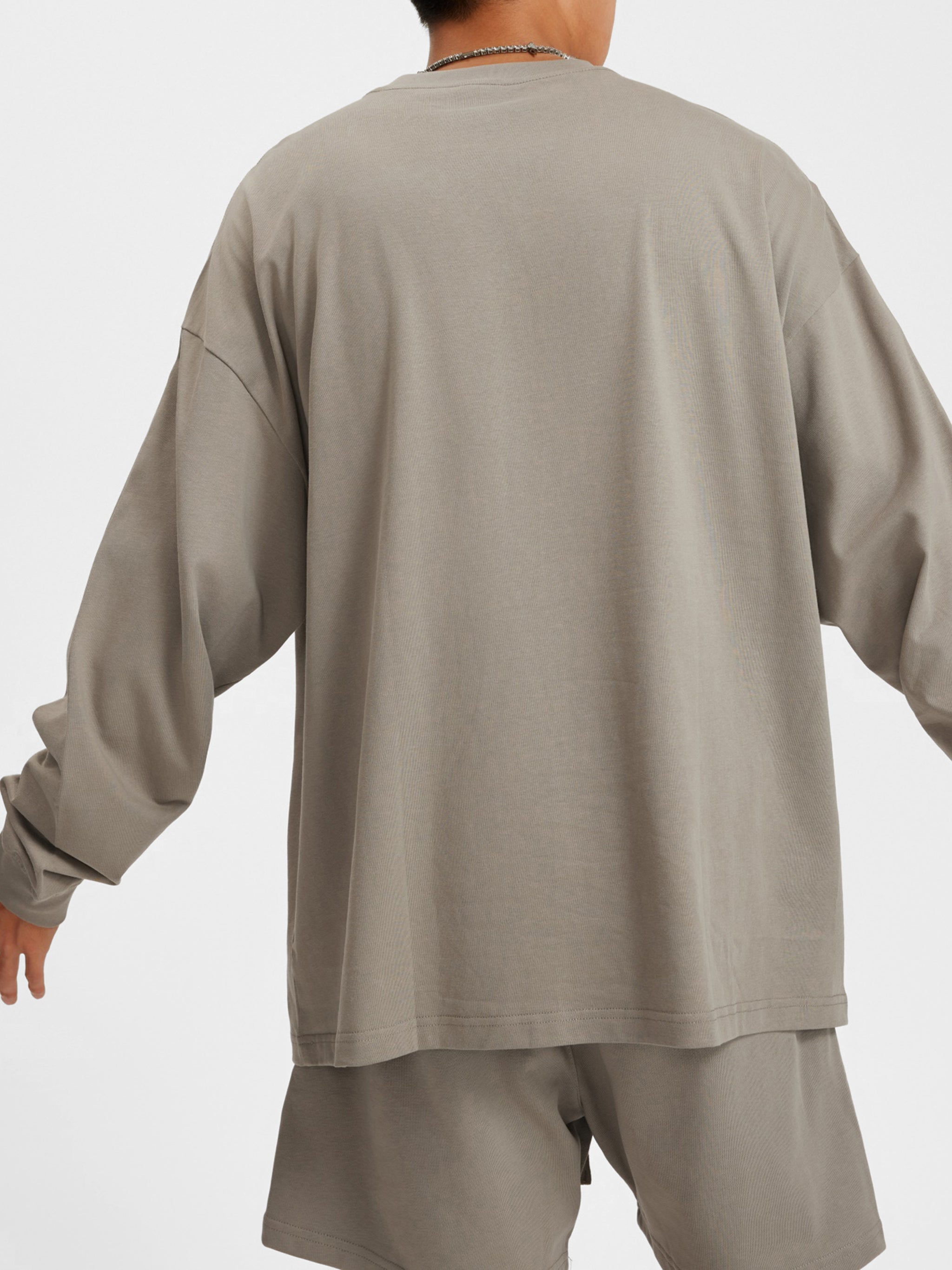 Back view of person wearing oversized beige heavyweight streetwear shirt and shorts