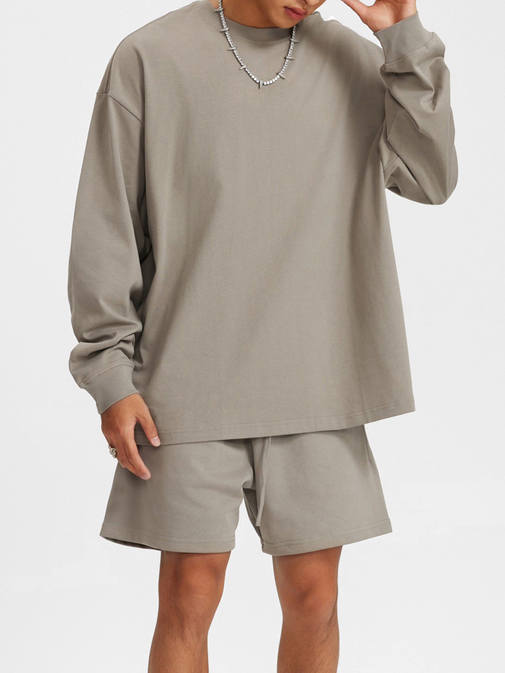 Man wearing taupe oversized long sleeve shirt and matching shorts, streetwear style