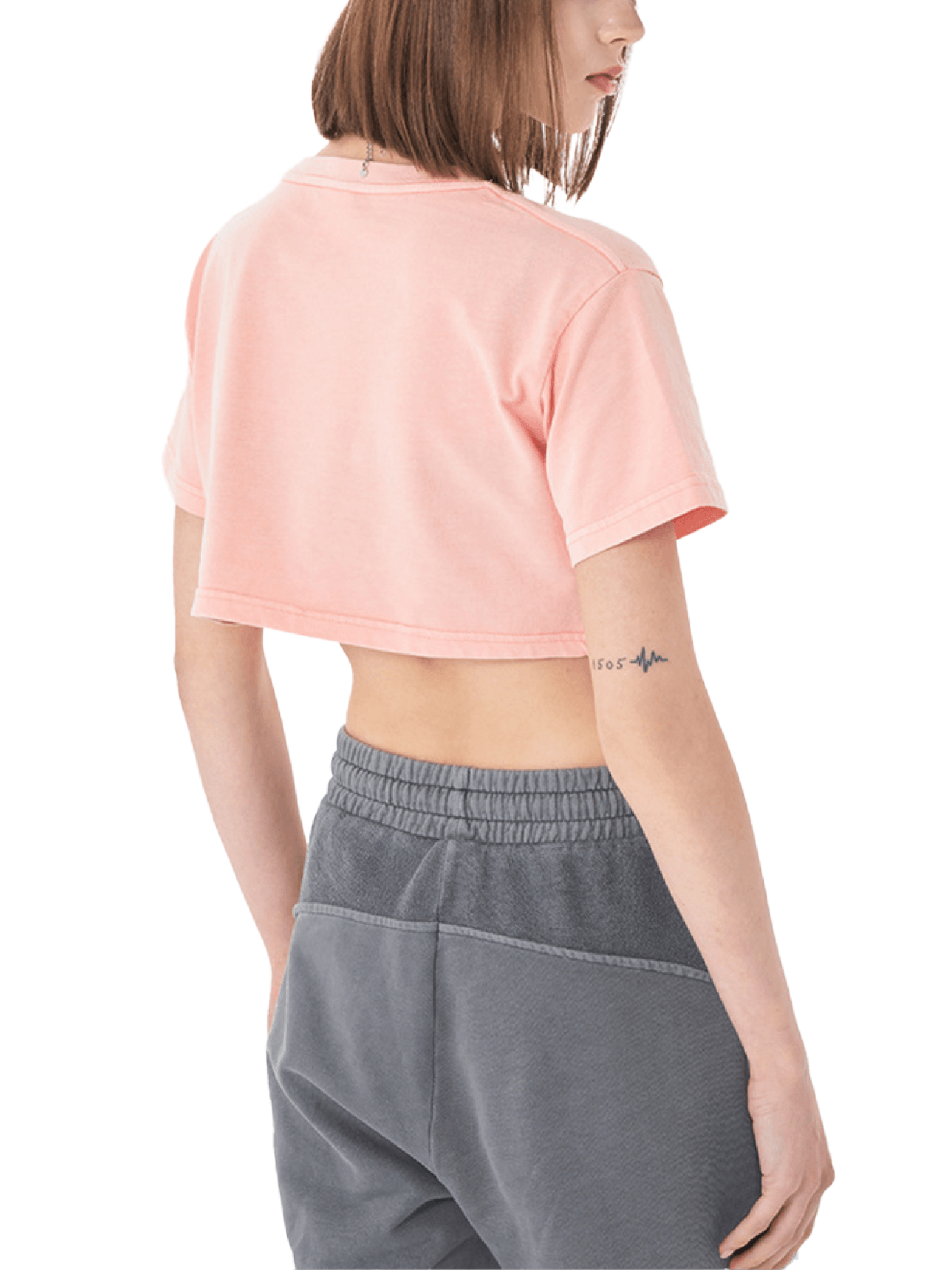 Woman in a pink cropped t-shirt and gray sweatpants, back view, casual streetwear style