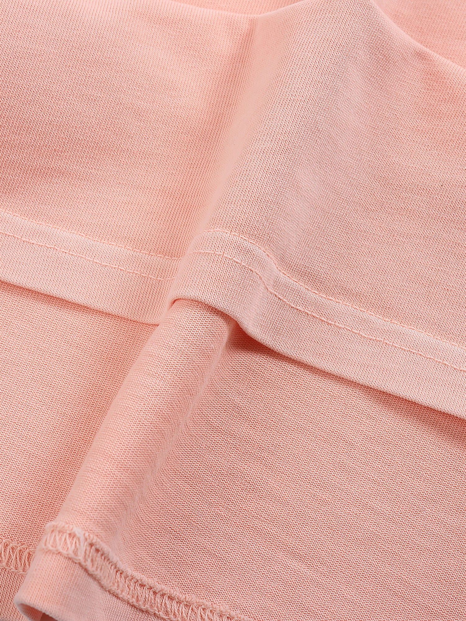 Close-up of peach pink heavyweight cotton fabric with visible stitching and soft texture