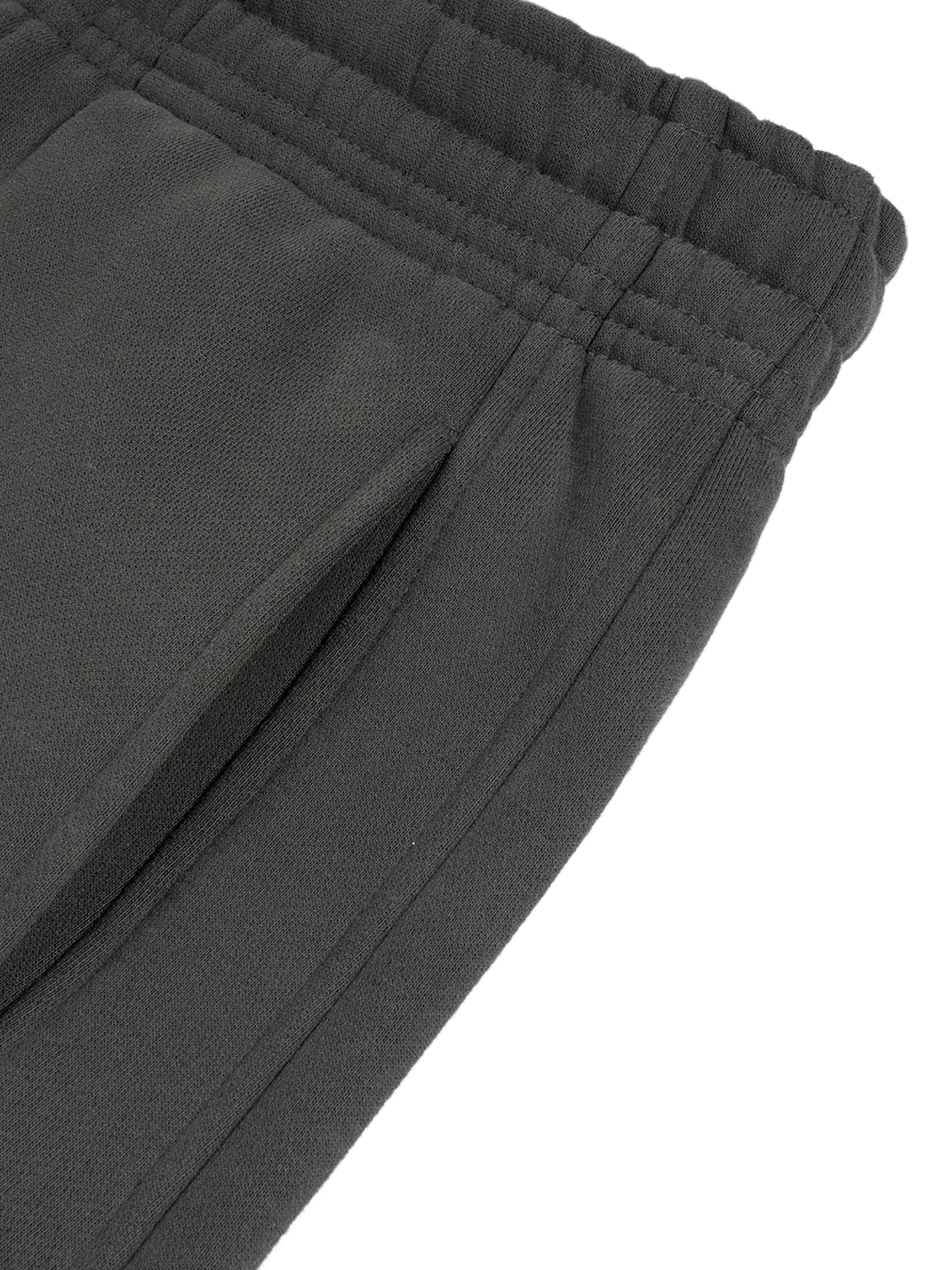 Close-up of black heavyweight streetwear sweatpants with elastic waistband and side pocket
