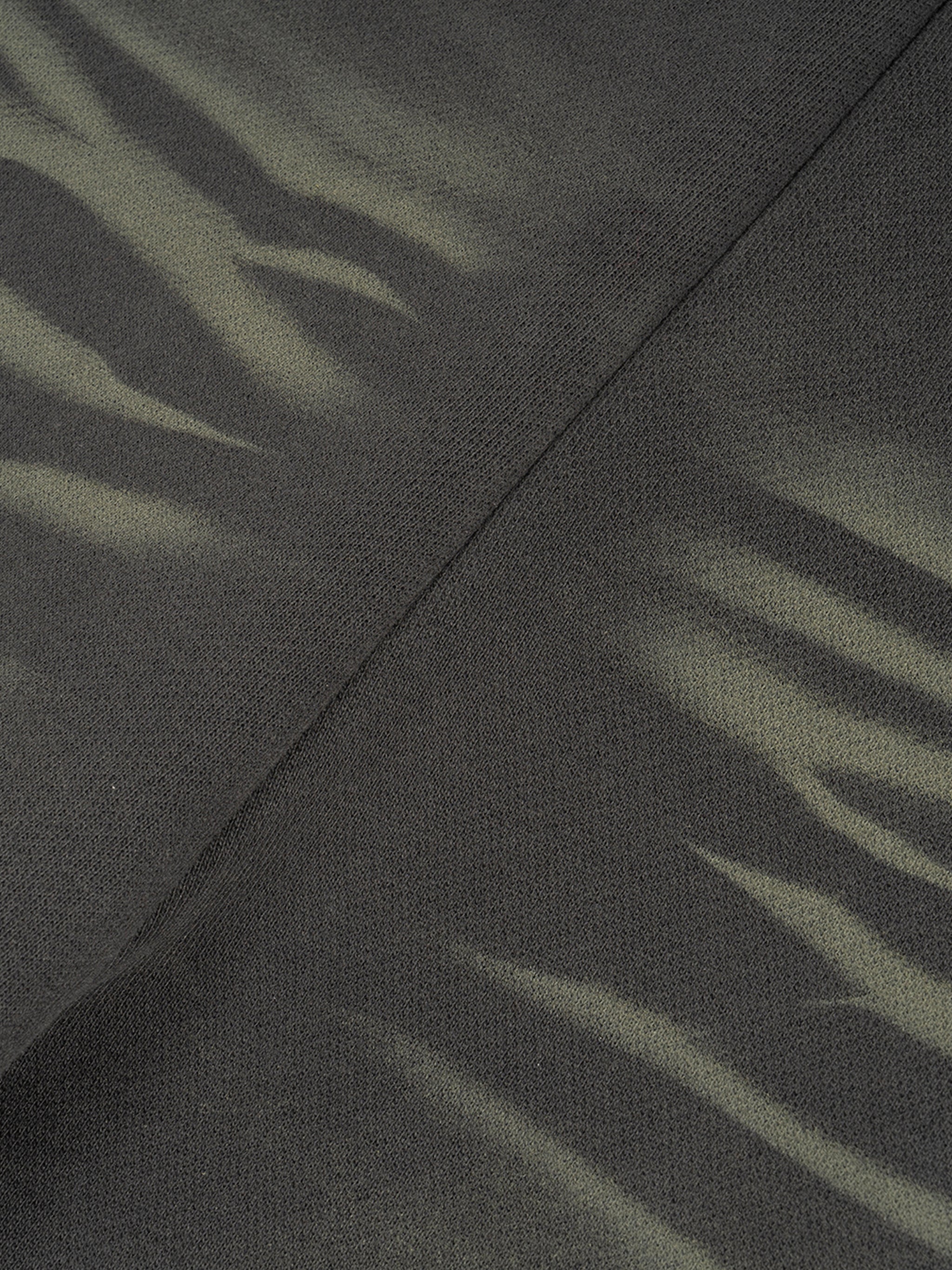 Close-up of heavyweight streetwear fabric with dark green and black tiger stripe pattern