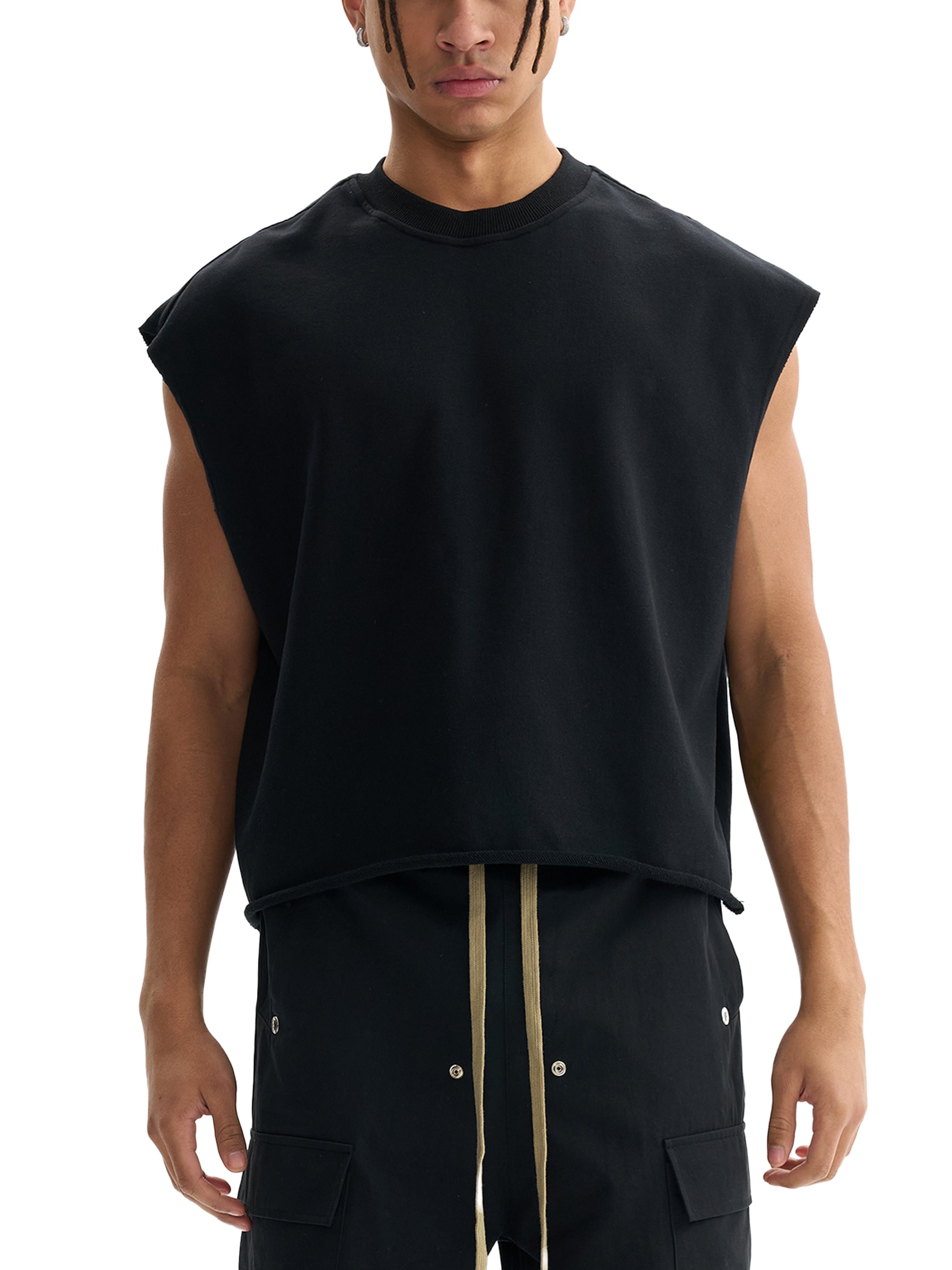 Man wearing a sleeveless black heavyweight streetwear top with relaxed fit and cargo pants