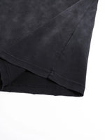 Tshirt close-up in black fabric with hand-frayed hem and sleeve seam.