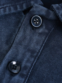 Close-up of dark blue denim shirt fabric with black buttons and visible stitching