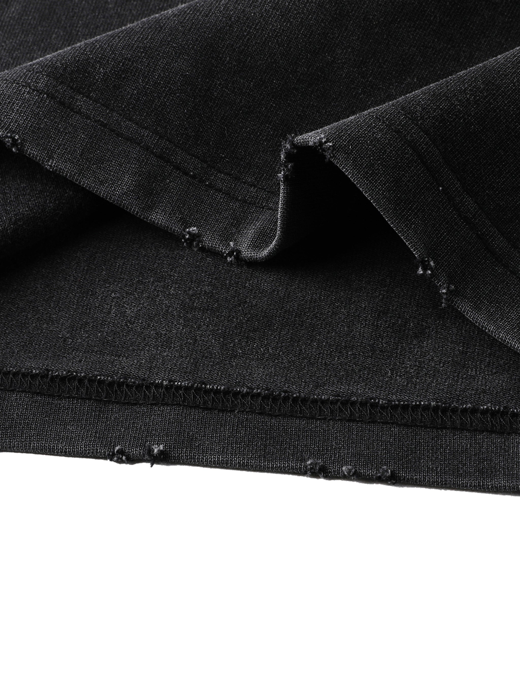 Closeup of black heavyweight streetwear fabric with distressed hem detail