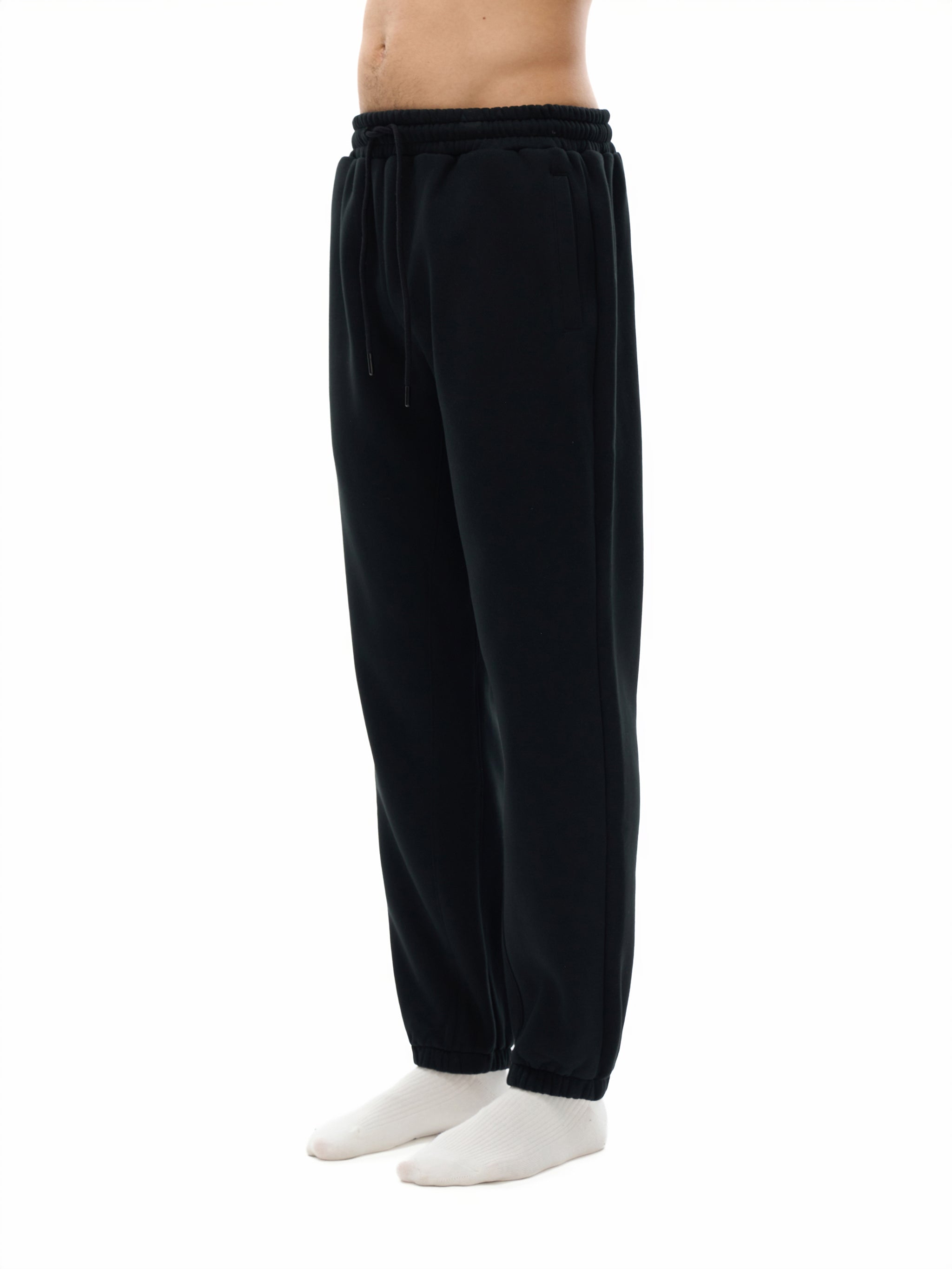 Side view of black heavyweight sweatpants with drawstring waist and elastic cuffs.