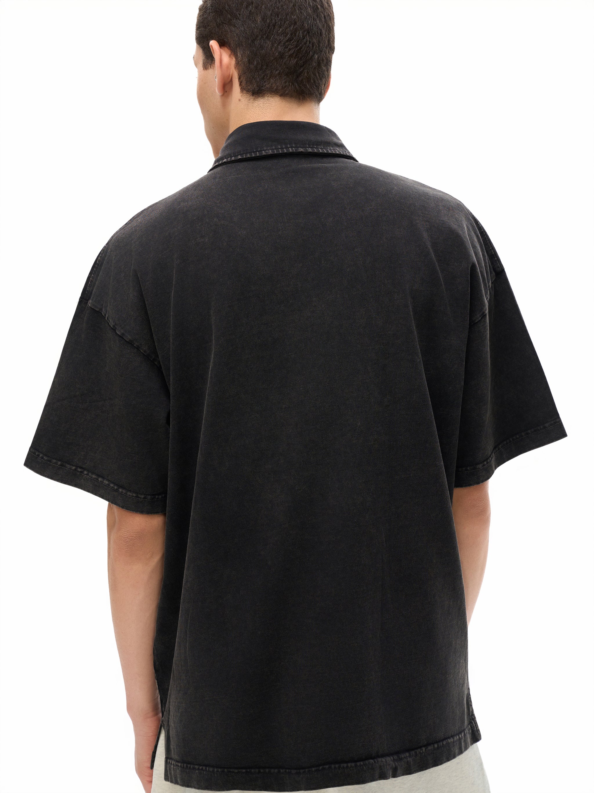 Back view of man wearing oversized black short sleeve heavyweight shirt