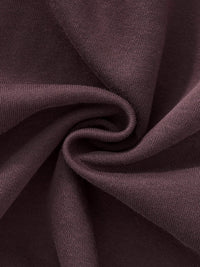 Close-up of heavyweight plum-colored knit streetwear fabric texture, twisted detail