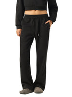 Woman wearing black heavyweight streetwear joggers and cropped sweatshirt on white background