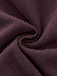 Close-up of heavyweight brown streetwear fabric with soft texture and subtle swirl pattern