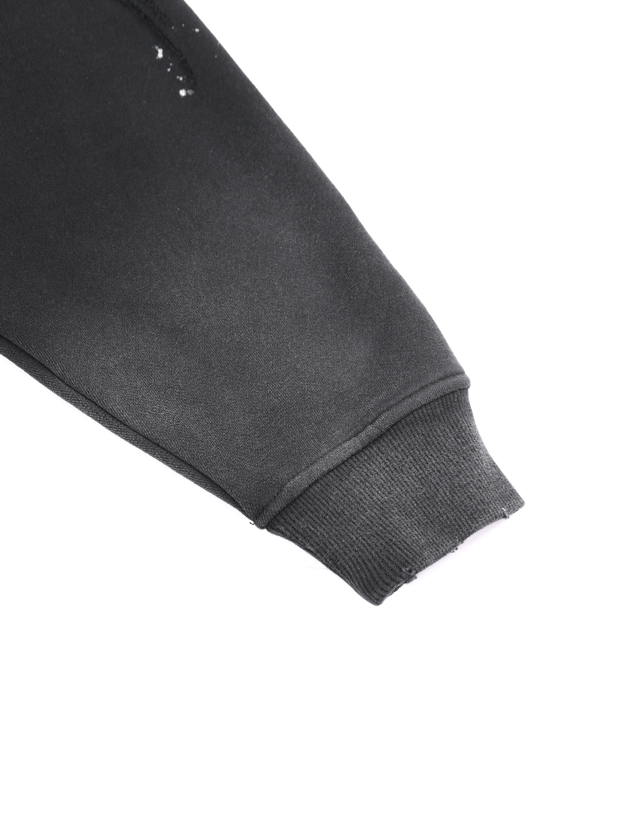 Close-up of black heavyweight sweatshirt sleeve with ribbed cuff on white background