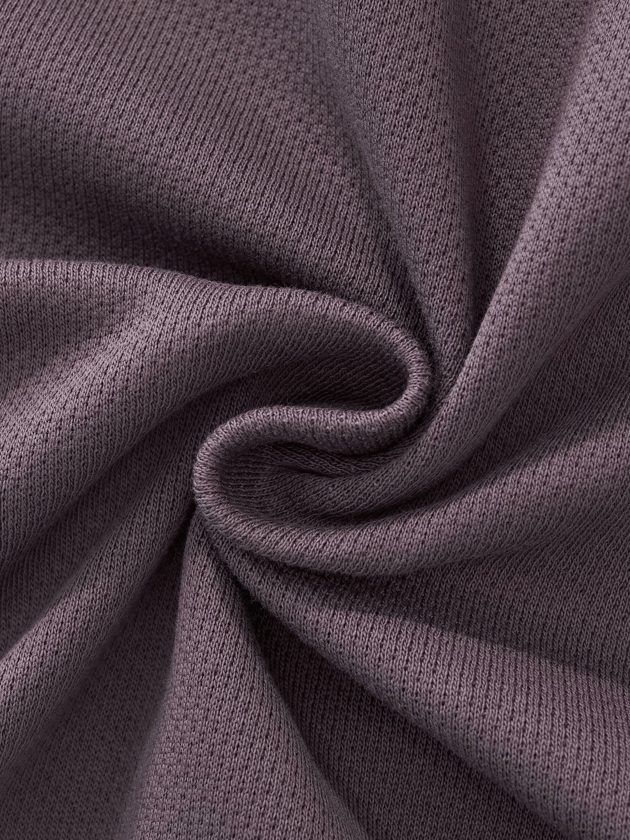 Close-up of heavyweight, textured gray knit streetwear fabric twisted in a swirl