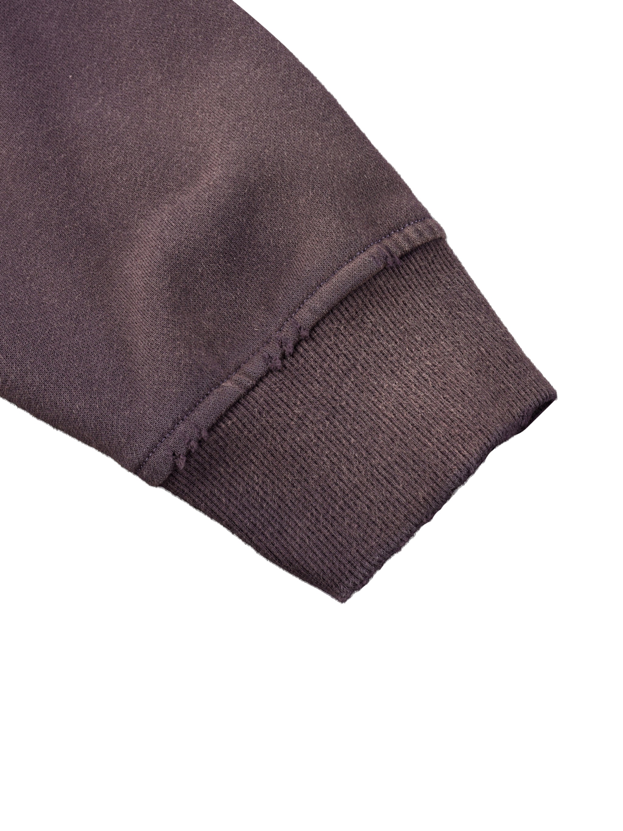 Close-up of heavyweight dark brown sweatshirt cuff with ribbed and raw seam details
