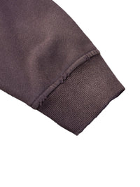 Close-up of heavyweight dark brown sweatshirt cuff with ribbed and raw seam details