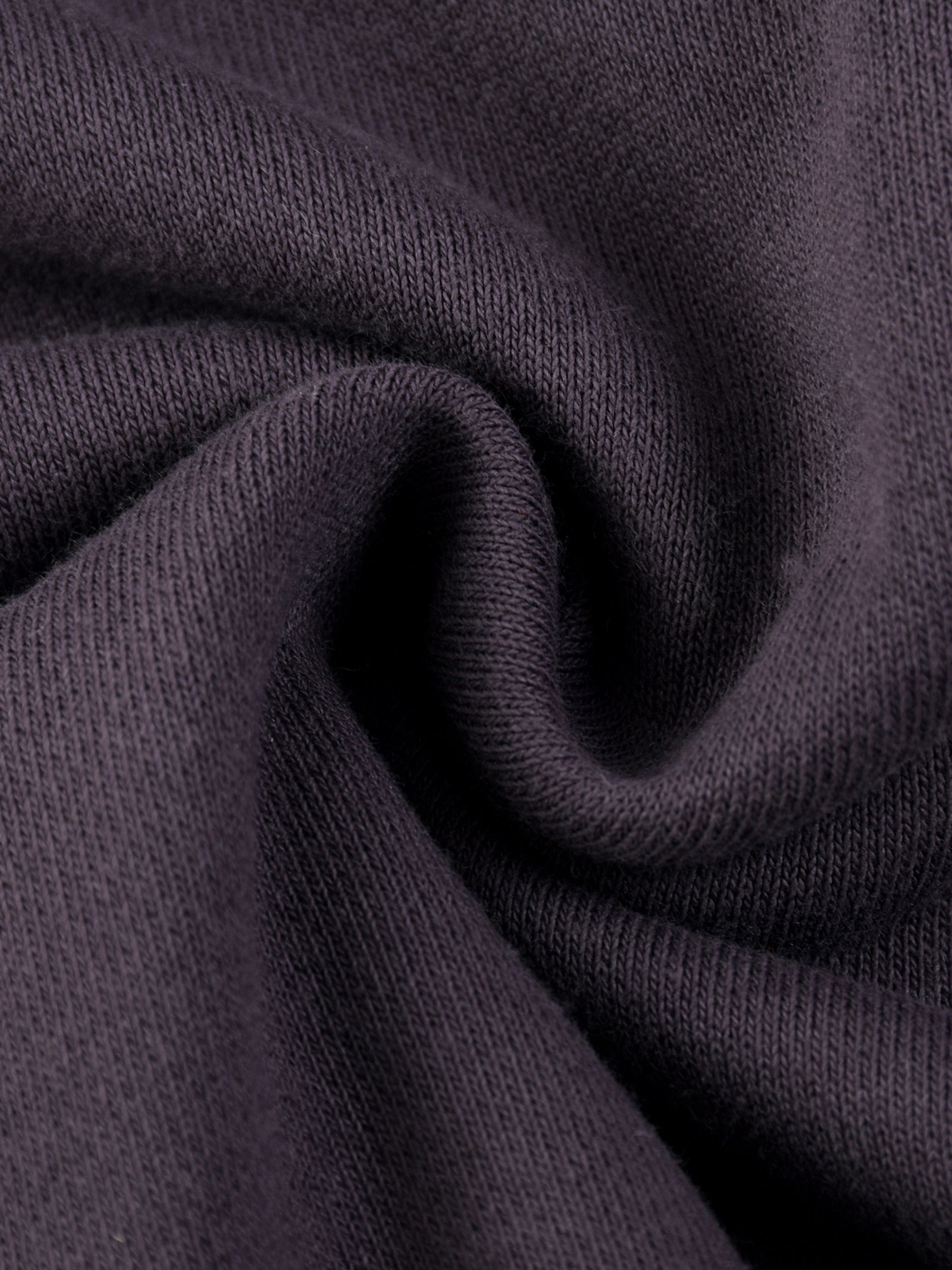 Close-up of heavyweight dark knit streetwear fabric with soft texture folds