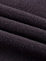 Close-up of heavyweight textured black fleece fabric, soft and cozy material folds