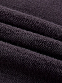 Close-up of heavyweight textured black fleece fabric, soft and cozy material folds