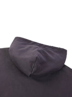 Close-up of a black heavyweight streetwear hoodie hood on a flat surface