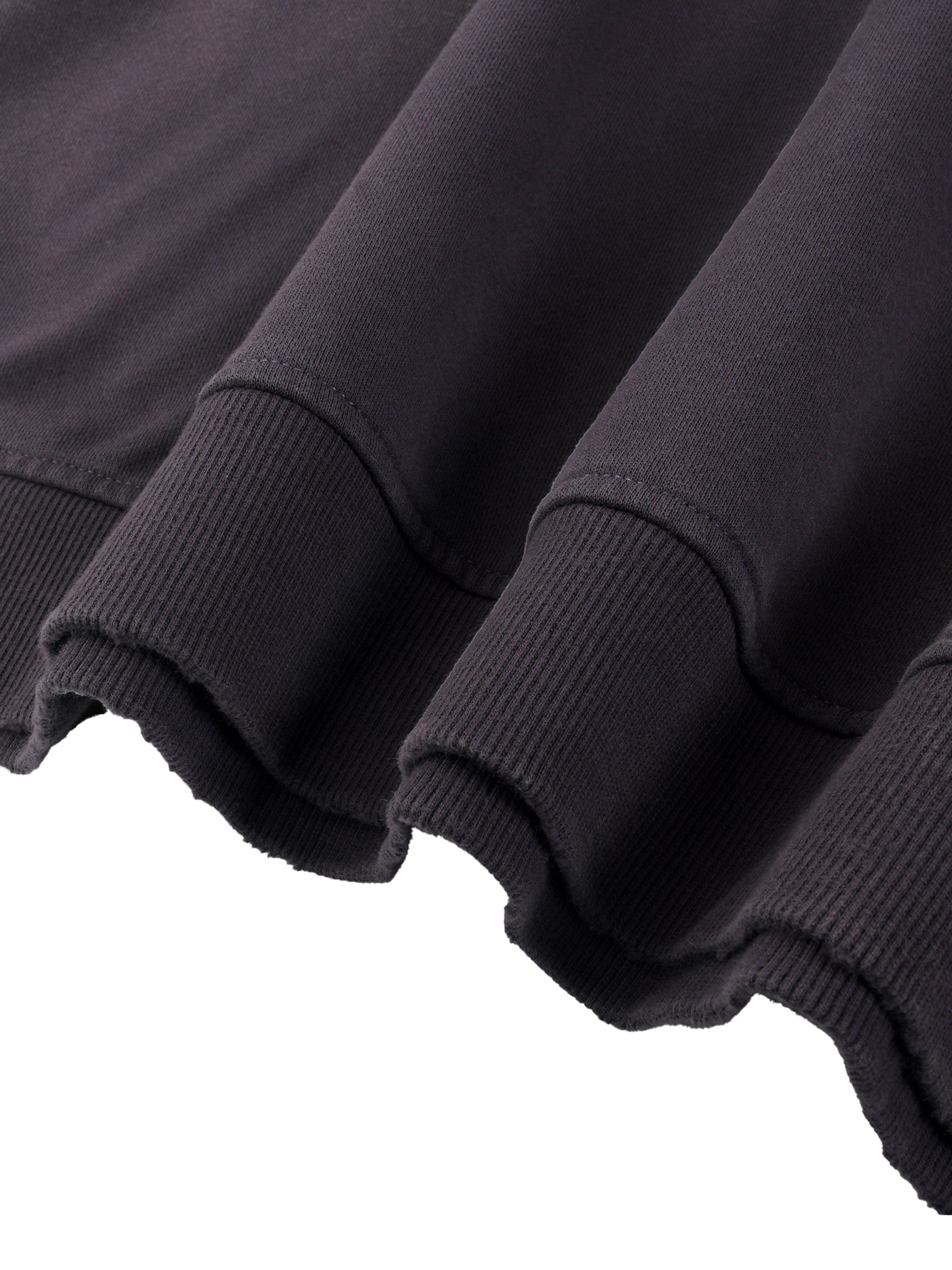 Close-up of heavyweight black streetwear sweatshirt with ribbed cuffs and raw hem
