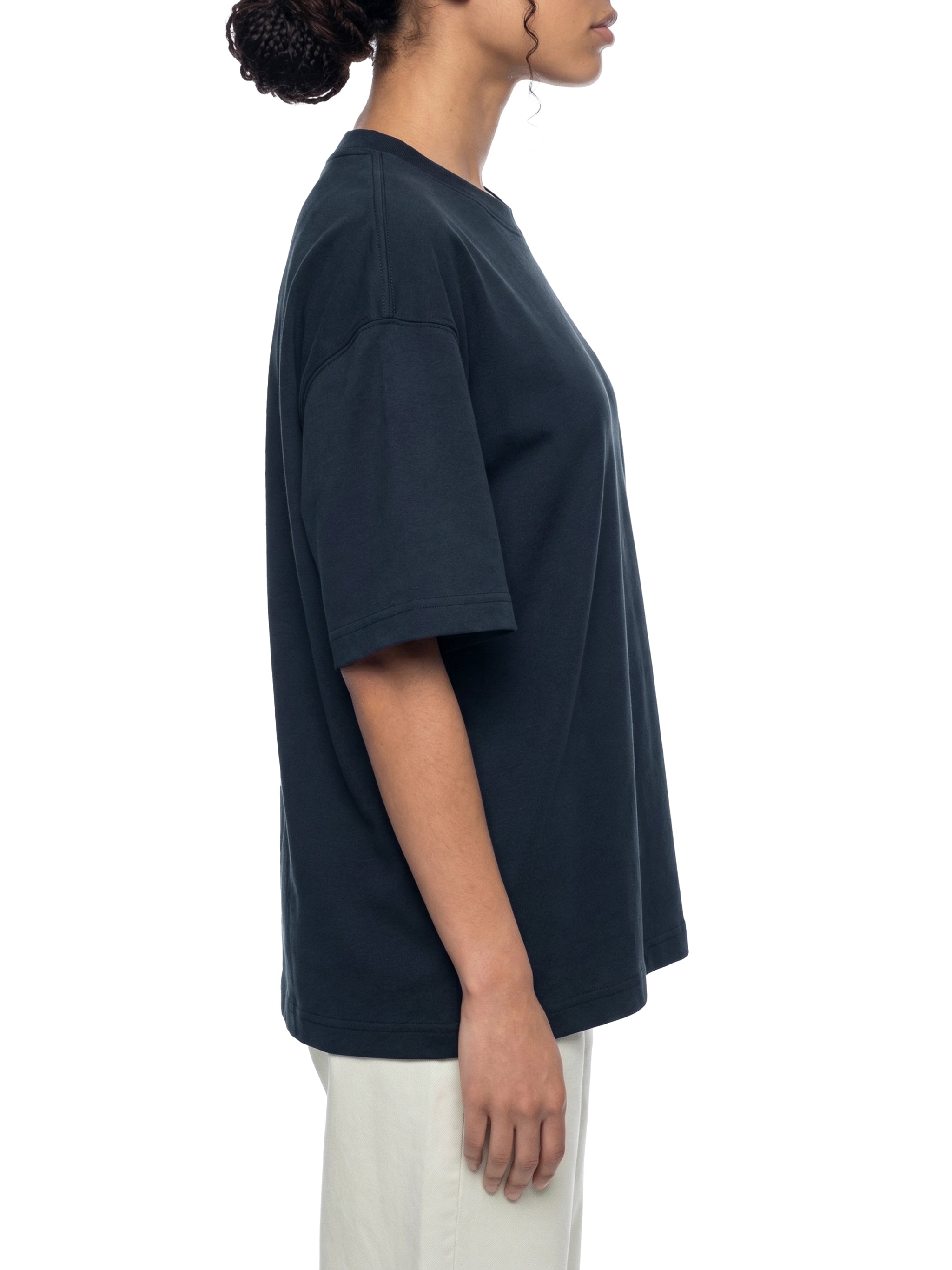 Side view of person wearing oversized black heavyweight t-shirt and light pants