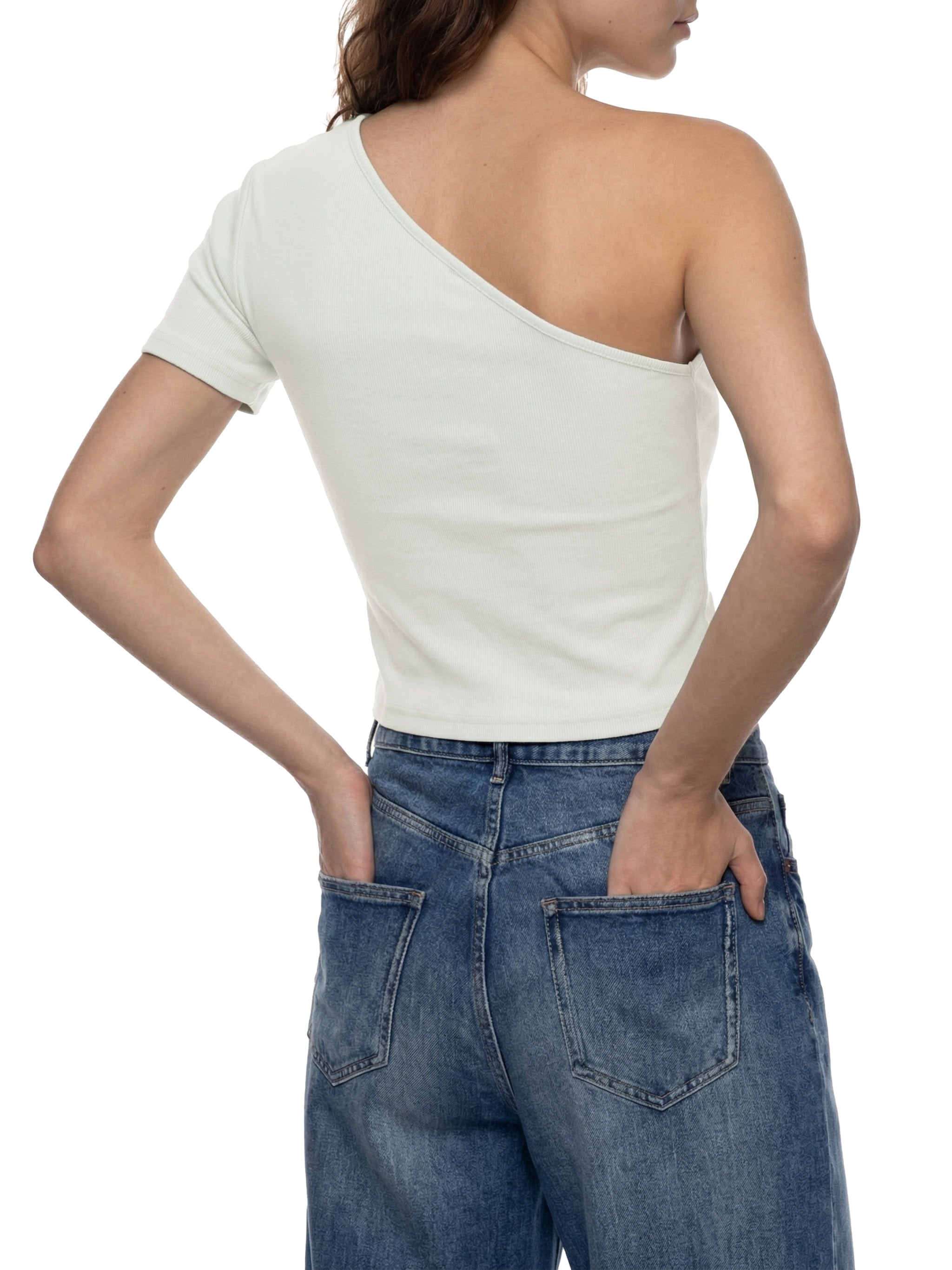 Woman wearing a white one-shoulder top and relaxed fit blue jeans, back view