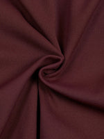 Bodysuit fabric close-up in burgundy with soft knit texture and folds.